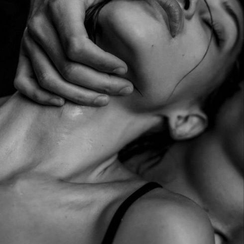 Eine Frau wird sanft am Kinn gehalten, mit weichem Licht und intensiven Emotionen.