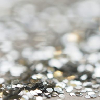 Silberner Glitzer auf einer unscharfen Oberfläche, funkelnd und schimmernd.