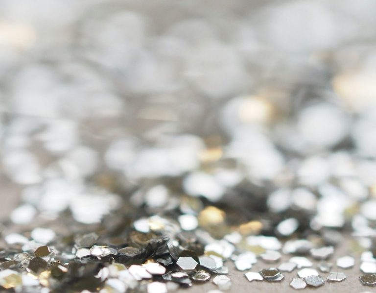 Herzförmiger, glitzernder Diamant auf grauem Hintergrund.