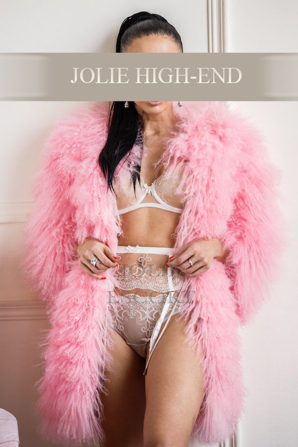 Highclass Escort in Berlin in pinkem, flauschigem Mantel und verführerischer Unterwäsche.