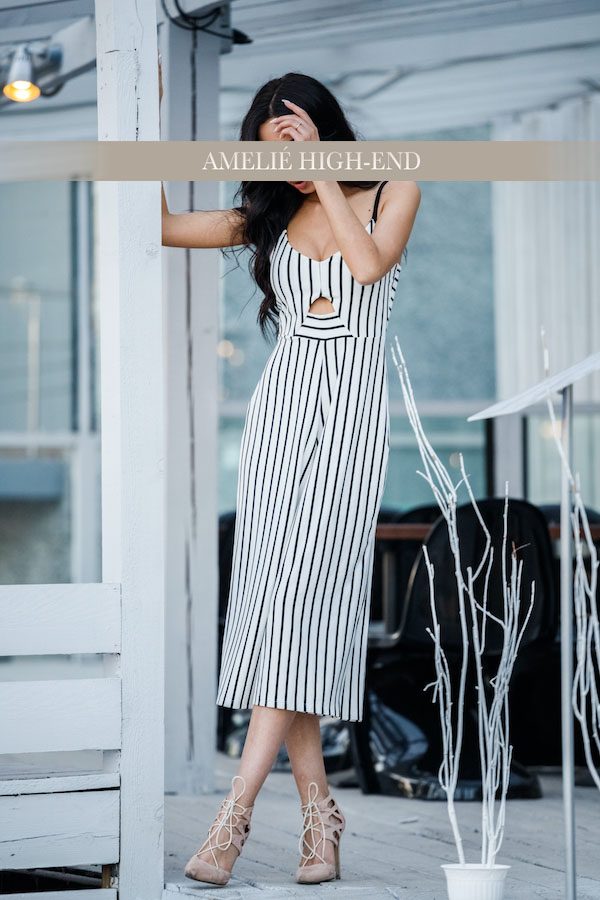 Eine Escort in einem gestreiften Kleid steht an einer Tür und hält sich das Gesicht.